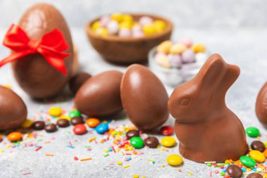 Arka planda paskalya çikolatalı yumurtası. Paskalya kutlaması. Paskalya çikolatalı tavşan. Çikolatalı tatlı yumurta. Şekerler ahşap masanın üzerinde. Mesaj için boşluk. Boşluğu kopyala. Hediye. Pankart.