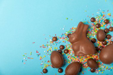 Arka planda paskalya çikolatalı yumurtası. Paskalya kutlaması. Paskalya çikolatalı tavşan. Çikolatalı tatlı yumurta. Şekerler ahşap masanın üzerinde. Mesaj için boşluk. Boşluğu kopyala. Hediye. Pankart.