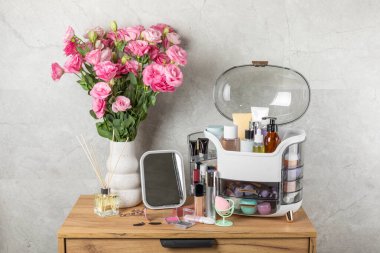 Makyaj masasında kozmetik ürünleri var. Kozmetik kutusu şifoniyerde. Vücut bakımı kozmetik ürünleri. Dekoratif ve bakım ürünü. Kozmetik çanta. Depo kutusu. Güzellik konsepti. Makyaj. Metin için boşluk.