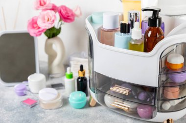 Makyaj masasında kozmetik ürünleri var. Kozmetik kutusu şifoniyerde. Vücut bakımı kozmetik ürünleri. Dekoratif ve bakım ürünü. Kozmetik çanta. Depo kutusu. Güzellik konsepti. Makyaj. Metin için boşluk.