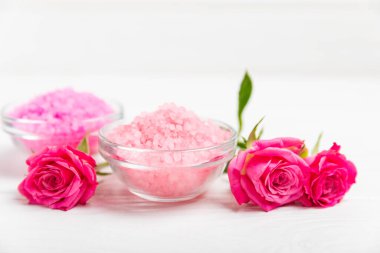 Banyo için deniz tuzu aromalı ve ahşap kaplamalı gül çiçekli. Pembe deniz tuzu. Spa tedavileri. Doğal tuz, bitkiler ve gerekli yağlar. Cilt bakımı. Mesaj için Meso. Boşluğu kopyala