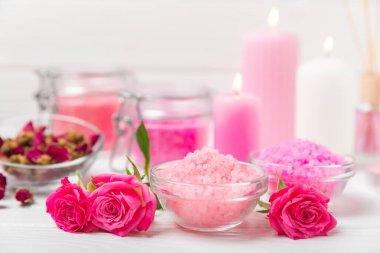 Banyo için deniz tuzu aromalı ve ahşap kaplamalı gül çiçekli. Pembe deniz tuzu. Spa tedavileri. Doğal tuz, bitkiler ve gerekli yağlar. Cilt bakımı. Mesaj için Meso. Boşluğu kopyala