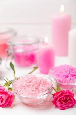 Banyo için deniz tuzu aromalı ve ahşap kaplamalı gül çiçekli. Pembe deniz tuzu. Spa tedavileri. Doğal tuz, bitkiler ve gerekli yağlar. Cilt bakımı. Mesaj için Meso. Boşluğu kopyala