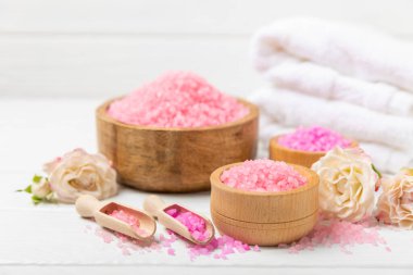 Banyo için deniz tuzu aromalı ve ahşap kaplamalı gül çiçekli. Pembe deniz tuzu. Spa tedavileri. Doğal tuz, bitkiler ve gerekli yağlar. Cilt bakımı. Mesaj için Meso. Boşluğu kopyala