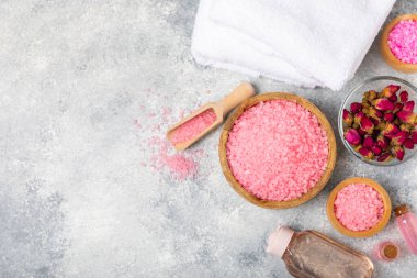 Banyo için deniz tuzu aromalı ve ahşap kaplamalı gül çiçekli. Pembe deniz tuzu. Spa tedavileri. Doğal tuz, bitkiler ve gerekli yağlar. Cilt bakımı. Mesaj için Meso. Boşluğu kopyala