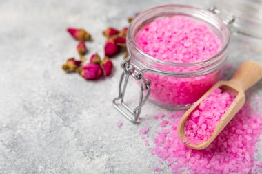 Banyo için deniz tuzu aromalı ve ahşap kaplamalı gül çiçekli. Pembe deniz tuzu. Spa tedavileri. Doğal tuz, bitkiler ve gerekli yağlar. Cilt bakımı. Mesaj için Meso. Boşluğu kopyala