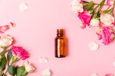 Arka planda gül yağı. Güller ve bir şişe parfümlü su. Romaterapi tedavisi. Güzellik konsepti. Spa prosedürü. Doğal organik yağ. Stres önleyici, detoks gevşetici.