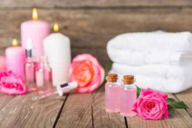 Arka planda gül yağı. Güller ve bir şişe parfümlü su. Romaterapi tedavisi. Güzellik konsepti. Spa prosedürü. Doğal organik yağ. Stres önleyici, detoks gevşetici.