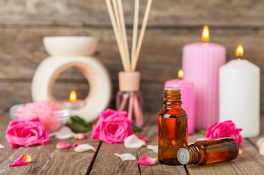 Arka planda gül yağı. Güller ve bir şişe parfümlü su. Romaterapi tedavisi. Güzellik konsepti. Spa prosedürü. Doğal organik yağ. Stres önleyici, detoks gevşetici.