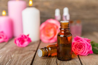 Arka planda gül yağı. Güller ve bir şişe parfümlü su. Romaterapi tedavisi. Güzellik konsepti. Spa prosedürü. Doğal organik yağ. Stres önleyici, detoks gevşetici.