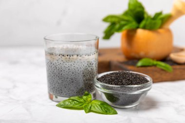 Dökümlü ahşap arka planda fesleğen tohumları. Yakın plan. Süper yemek. Ocimum bazilika. Organik fesleğen tohumu. selasih. Mesaj için yer var. Boşluğu kopyala.