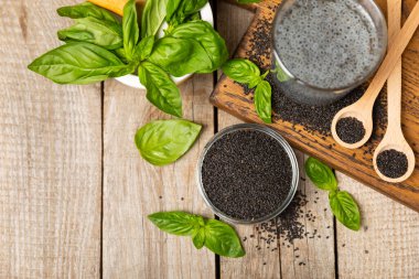 Dökümlü ahşap arka planda fesleğen tohumları. Yakın plan. Süper yemek. Ocimum bazilika. Organik fesleğen tohumu. selasih. Mesaj için yer var. Boşluğu kopyala.