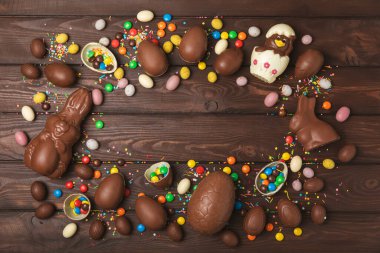Arka planda paskalya çikolatalı yumurtası. Paskalya kutlaması. Paskalya çikolatalı tavşan. Çikolatalı tatlı yumurta. Şekerler ahşap masanın üzerinde. Mesaj için boşluk. Boşluğu kopyala. Hediye. Pankart.