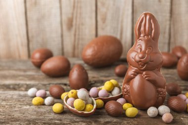 Arka planda paskalya çikolatalı yumurtası. Paskalya kutlaması. Paskalya çikolatalı tavşan. Çikolatalı tatlı yumurta. Şekerler ahşap masanın üzerinde. Mesaj için boşluk. Boşluğu kopyala. Hediye. Pankart.