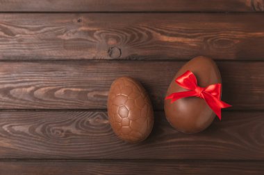 Arka planda paskalya çikolatalı yumurtası. Paskalya kutlaması. Paskalya çikolatalı tavşan. Çikolatalı tatlı yumurta. Şekerler ahşap masanın üzerinde. Mesaj için boşluk. Boşluğu kopyala. Hediye. Pankart.