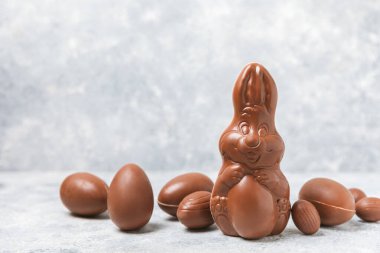 Arka planda paskalya çikolatalı yumurtası. Paskalya kutlaması. Paskalya çikolatalı tavşan. Çikolatalı tatlı yumurta. Şekerler ahşap masanın üzerinde. Mesaj için boşluk. Boşluğu kopyala. Hediye. Pankart.