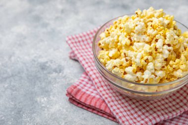 Parlak renkli arka planda tuzlu patlamış mısır. Sinema ve eğlence anlayışı. Patlamış mısırla film gecesi. Lezzetli aperatif, atıştırmalık. Mesaj için yer, fotokopi alanı. Pankart