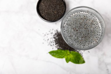 Dökümlü ahşap arka planda fesleğen tohumları. Yakın plan. Süper yemek. Ocimum bazilika. Organik fesleğen tohumu. selasih. Mesaj için yer var. Boşluğu kopyala.