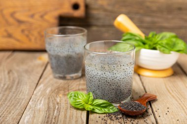 Dökümlü ahşap arka planda fesleğen tohumları. Yakın plan. Süper yemek. Ocimum bazilika. Organik fesleğen tohumu. selasih. Mesaj için yer var. Boşluğu kopyala.