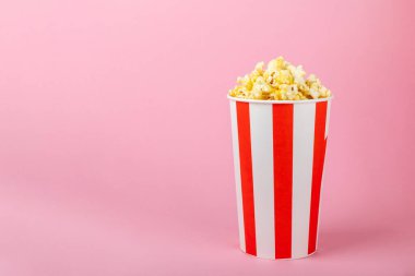 Parlak renkli arka planda tuzlu patlamış mısır. Sinema ve eğlence anlayışı. Patlamış mısırla film gecesi. Lezzetli aperatif, atıştırmalık. Mesaj için yer, fotokopi alanı. Pankart