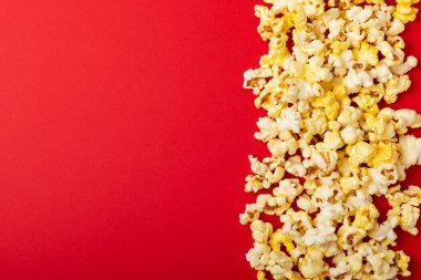 Parlak renkli arka planda tuzlu patlamış mısır. Sinema ve eğlence anlayışı. Patlamış mısırla film gecesi. Lezzetli aperatif, atıştırmalık. Mesaj için yer, fotokopi alanı. Pankart