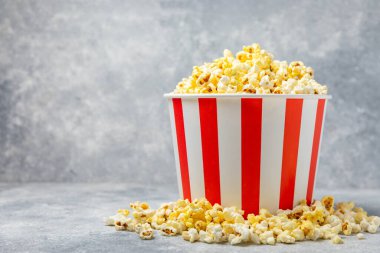 Parlak renkli arka planda tuzlu patlamış mısır. Sinema ve eğlence anlayışı. Patlamış mısırla film gecesi. Lezzetli aperatif, atıştırmalık. Mesaj için yer, fotokopi alanı. Pankart