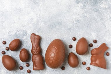 Arka planda paskalya çikolatalı yumurtası. Paskalya kutlaması. Paskalya çikolatalı tavşan. Çikolatalı tatlı yumurta. Şekerler ahşap masanın üzerinde. Mesaj için boşluk. Boşluğu kopyala. Hediye. Pankart.