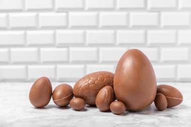 Arka planda paskalya çikolatalı yumurtası. Paskalya kutlaması. Paskalya çikolatalı tavşan. Çikolatalı tatlı yumurta. Şekerler ahşap masanın üzerinde. Mesaj için boşluk. Boşluğu kopyala. Hediye. Pankart.