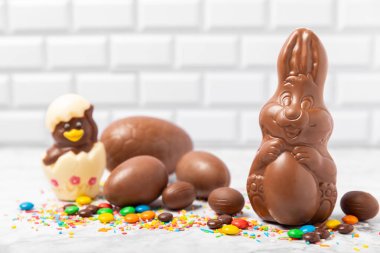 Arka planda paskalya çikolatalı yumurtası. Paskalya kutlaması. Paskalya çikolatalı tavşan. Çikolatalı tatlı yumurta. Şekerler ahşap masanın üzerinde. Mesaj için boşluk. Boşluğu kopyala. Hediye. Pankart.