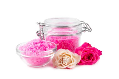 Beyaz arka planda gül aromalı banyo için deniz tuzu. Pembe deniz tuzu. Spa tedavileri. Doğal tuz, bitkiler ve gerekli yağlar. Cilt konsepti.