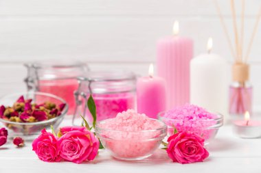 Banyo için deniz tuzu aromalı ve ahşap kaplamalı gül çiçekli. Pembe deniz tuzu. Spa tedavileri. Doğal tuz, bitkiler ve gerekli yağlar. Cilt bakımı. Mesaj için Meso. Boşluğu kopyala