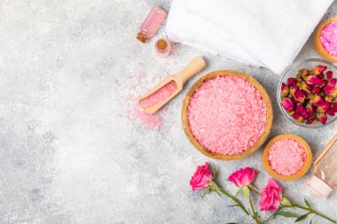 Banyo için deniz tuzu aromalı ve ahşap kaplamalı gül çiçekli. Pembe deniz tuzu. Spa tedavileri. Doğal tuz, bitkiler ve gerekli yağlar. Cilt bakımı. Mesaj için Meso. Boşluğu kopyala