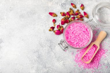 Banyo için deniz tuzu aromalı ve ahşap kaplamalı gül çiçekli. Pembe deniz tuzu. Spa tedavileri. Doğal tuz, bitkiler ve gerekli yağlar. Cilt bakımı. Mesaj için Meso. Boşluğu kopyala