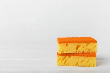 Arka planda renkli bulaşık süngerleri. Mutfak süngeri. Temizlik konsepti, temizlik hizmeti. Bulaşık deterjanı ve temiz ve kirli tabaklar. Metin için yer, kopyalama alanı. Bulaşıkları yıka..