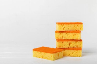 Arka planda renkli bulaşık süngerleri. Mutfak süngeri. Temizlik konsepti, temizlik hizmeti. Bulaşık deterjanı ve temiz ve kirli tabaklar. Metin için yer, kopyalama alanı. Bulaşıkları yıka..