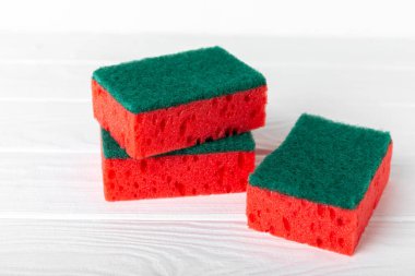 Arka planda renkli bulaşık süngerleri. Mutfak süngeri. Temizlik konsepti, temizlik hizmeti. Bulaşık deterjanı ve temiz ve kirli tabaklar. Metin için yer, kopyalama alanı. Bulaşıkları yıka..