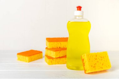 Arka planda renkli bulaşık süngerleri. Mutfak süngeri. Temizlik konsepti, temizlik hizmeti. Bulaşık deterjanı ve temiz ve kirli tabaklar. Metin için yer, kopyalama alanı. Bulaşıkları yıka..