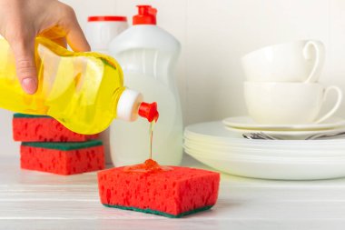 Arka planda renkli bulaşık süngerleri. Mutfak süngeri. Temizlik konsepti, temizlik hizmeti. Bulaşık deterjanı ve temiz ve kirli tabaklar. Metin için yer, kopyalama alanı. Bulaşıkları yıka..