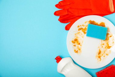 Arka planda renkli bulaşık süngerleri. Mutfak süngeri. Temizlik konsepti, temizlik hizmeti. Bulaşık deterjanı ve temiz ve kirli tabaklar. Metin için yer, kopyalama alanı. Bulaşıkları yıka..