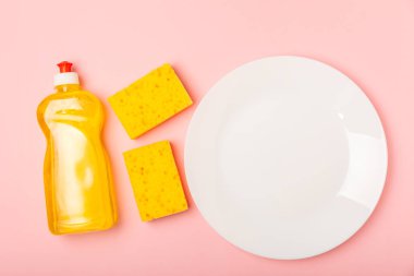 Arka planda renkli bulaşık süngerleri. Mutfak süngeri. Temizlik konsepti, temizlik hizmeti. Bulaşık deterjanı ve temiz ve kirli tabaklar. Metin için yer, kopyalama alanı. Bulaşıkları yıka..