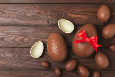 Arka planda paskalya çikolatalı yumurtası. Paskalya kutlaması. Paskalya çikolatalı tavşan. Çikolatalı tatlı yumurta. Şekerler ahşap masanın üzerinde. Mesaj için boşluk. Boşluğu kopyala. Hediye. Pankart.