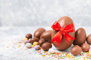 Arka planda paskalya çikolatalı yumurtası. Paskalya kutlaması. Paskalya çikolatalı tavşan. Çikolatalı tatlı yumurta. Şekerler ahşap masanın üzerinde. Mesaj için boşluk. Boşluğu kopyala. Hediye. Pankart.