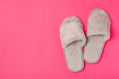 Açık renkli arka planda yumuşak terlikler, yakın plan. Ev terlikleri. Ev için rahat ayakkabılar. Ayak bakımı konsepti. Ev rahatlığı. Mesaj için yer var. Boşluğu kopyala.