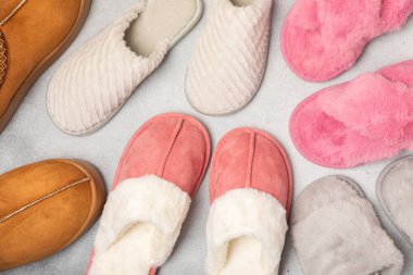 Açık renkli arka planda yumuşak terlikler, yakın plan. Ev terlikleri. Ev için rahat ayakkabılar. Ayak bakımı konsepti. Ev rahatlığı. Mesaj için yer var. Boşluğu kopyala.