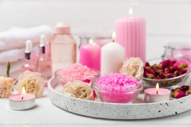 Banyo için deniz tuzu aromalı ve ahşap kaplamalı gül çiçekli. Pembe deniz tuzu. Spa tedavileri. Doğal tuz, bitkiler ve gerekli yağlar. Cilt bakımı. Mesaj için Meso. Boşluğu kopyala