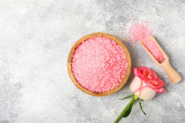 Banyo için deniz tuzu aromalı ve ahşap kaplamalı gül çiçekli. Pembe deniz tuzu. Spa tedavileri. Doğal tuz, bitkiler ve gerekli yağlar. Cilt bakımı. Mesaj için Meso. Boşluğu kopyala