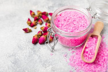 Banyo için deniz tuzu aromalı ve ahşap kaplamalı gül çiçekli. Pembe deniz tuzu. Spa tedavileri. Doğal tuz, bitkiler ve gerekli yağlar. Cilt bakımı. Mesaj için Meso. Boşluğu kopyala
