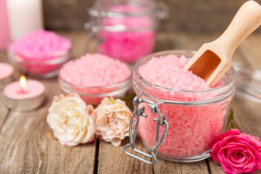 Banyo için deniz tuzu aromalı ve ahşap kaplamalı gül çiçekli. Pembe deniz tuzu. Spa tedavileri. Doğal tuz, bitkiler ve gerekli yağlar. Cilt bakımı. Mesaj için Meso. Boşluğu kopyala