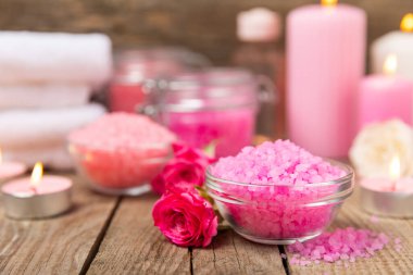 Banyo için deniz tuzu aromalı ve ahşap kaplamalı gül çiçekli. Pembe deniz tuzu. Spa tedavileri. Doğal tuz, bitkiler ve gerekli yağlar. Cilt bakımı. Mesaj için Meso. Boşluğu kopyala