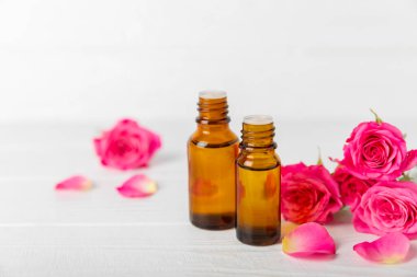 Arka planda gül yağı. Güller ve bir şişe parfümlü su. Romaterapi tedavisi. Güzellik konsepti. Spa prosedürü. Doğal organik yağ. Stres önleyici, detoks gevşetici.